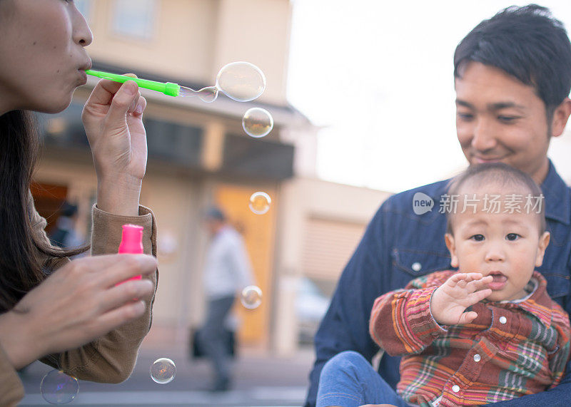 年轻的妈妈吹着泡泡