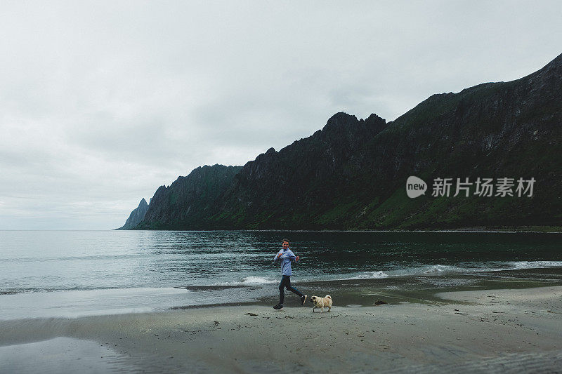 在挪威，一个女人带着狗在雨中奔跑