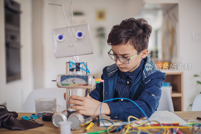 聪明的男孩工程师为学校的科学项目建造一个机器人