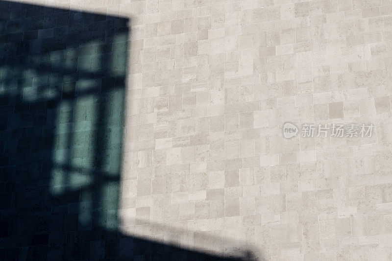 玻璃和钢铁建筑的影子投射在石灰石墙上
