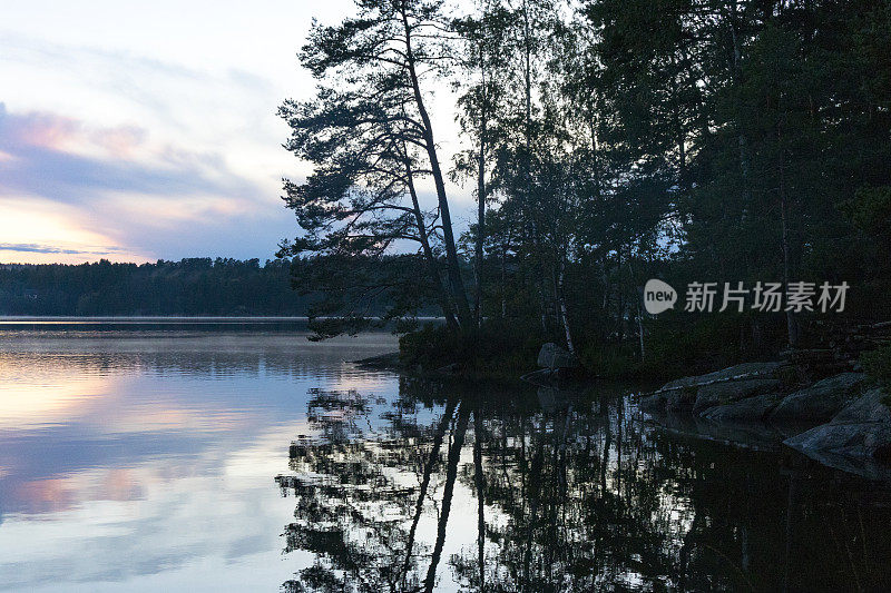 夏日傍晚，瑞典平静的湖面上的日落