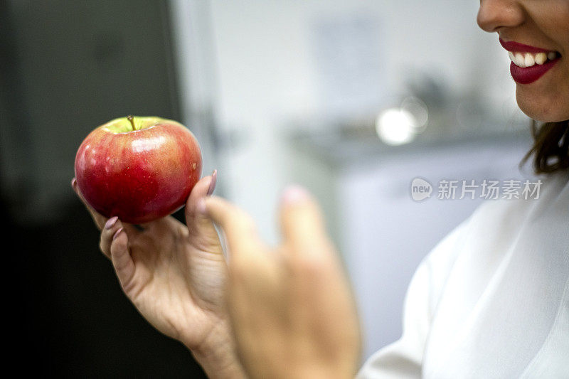 看牙医的女人手里拿着红苹果