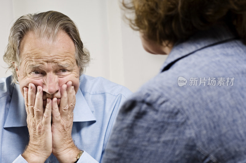 心烦意乱的高级男子与手在脸上咨询会议。