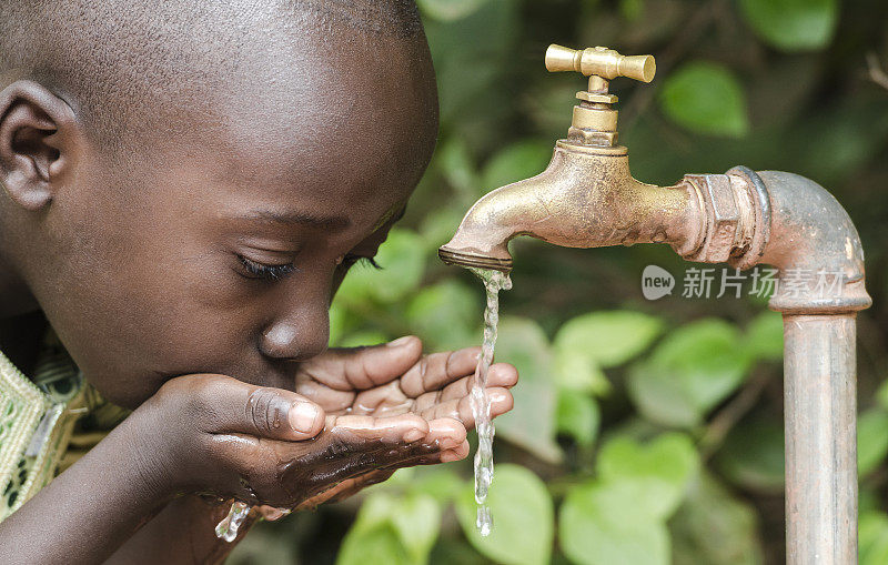 骄傲的黑人男孩从水龙头喝水非洲