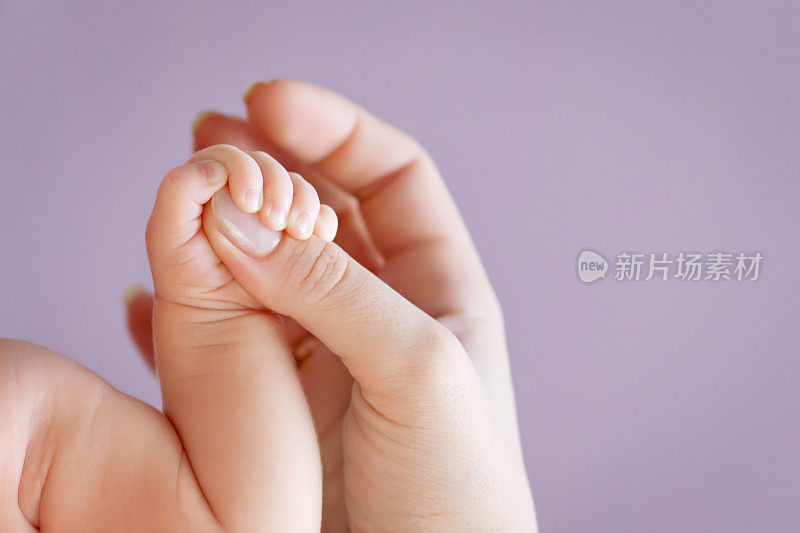 新生儿的手握在母亲的手里。妈妈和孩子。