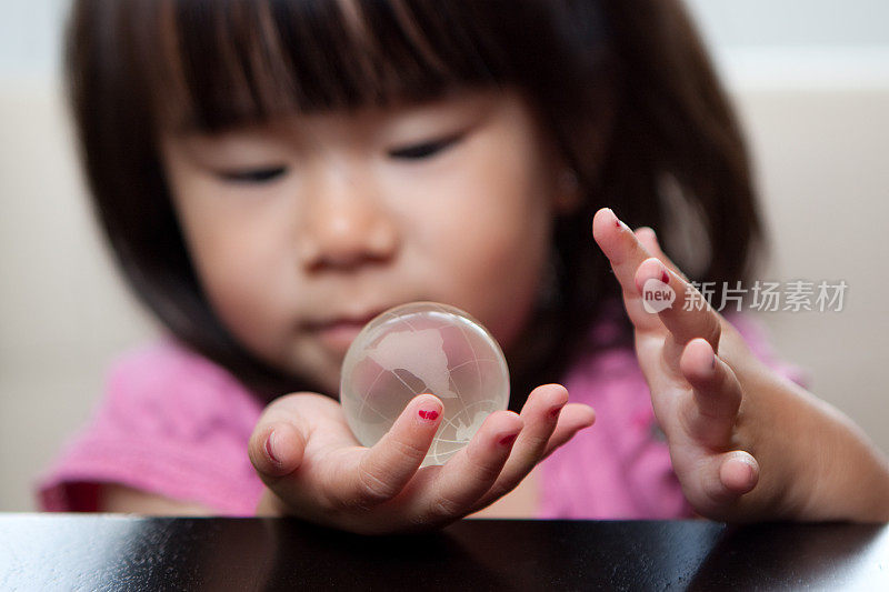 亚洲小女孩拿着玻璃球