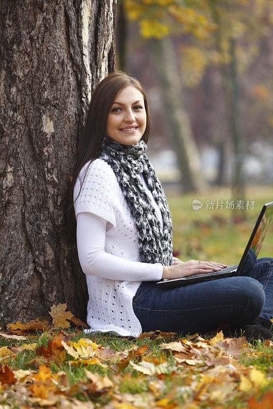 年轻女子在大自然中用笔记本电脑工作