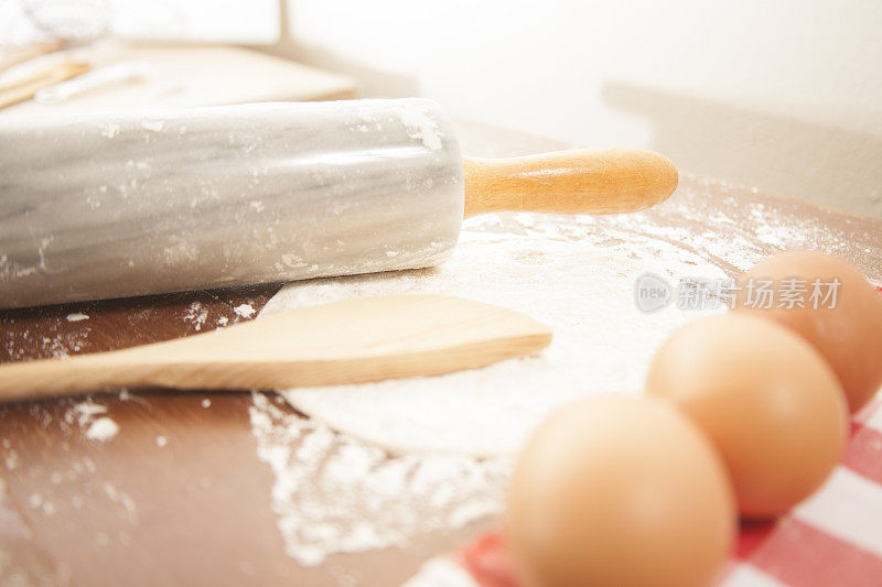 烘焙的概念。厨房柜台上的擀面杖，勺子，面粉，鸡蛋。