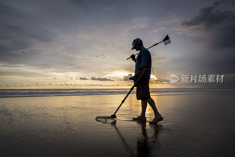 海滩上的寻宝人，带着金属探测器