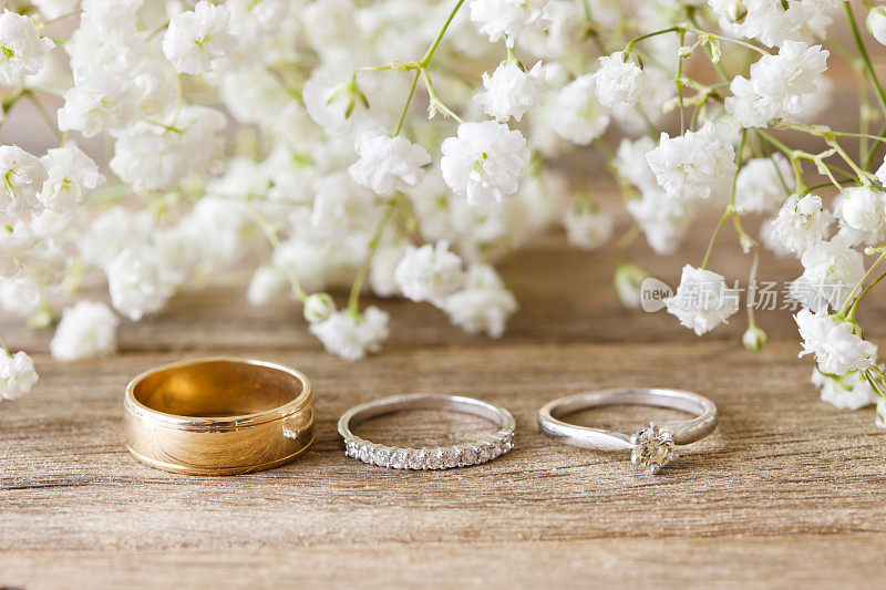 婚礼戒指和订婚戒指在乡村木材桌上