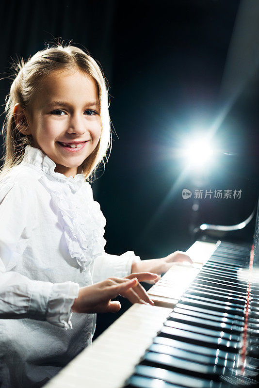 可爱的女孩在弹钢琴。