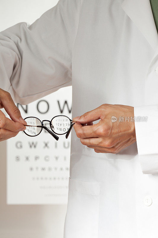 手持眼镜的验光师用视力表进行检查