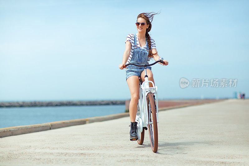 年轻女子在海边骑车