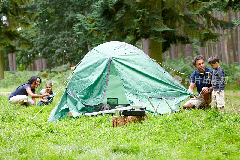 快乐的年轻家庭搭建帐篷露营