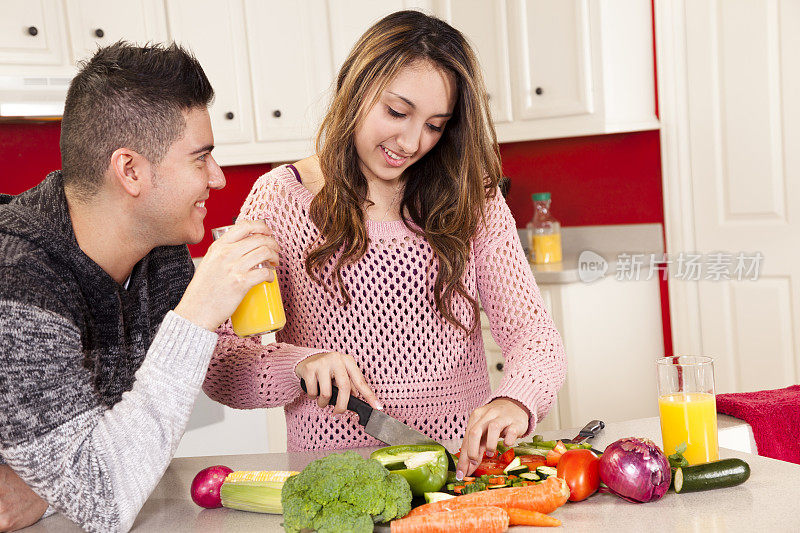 年轻夫妇准备健康的午餐。厨房。水果、蔬菜、沙拉。