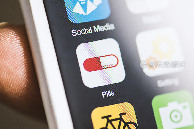 手持手机，屏幕上的药片提醒应用程序