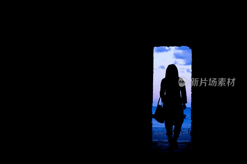 一个女人穿过黑暗隧道的剪影