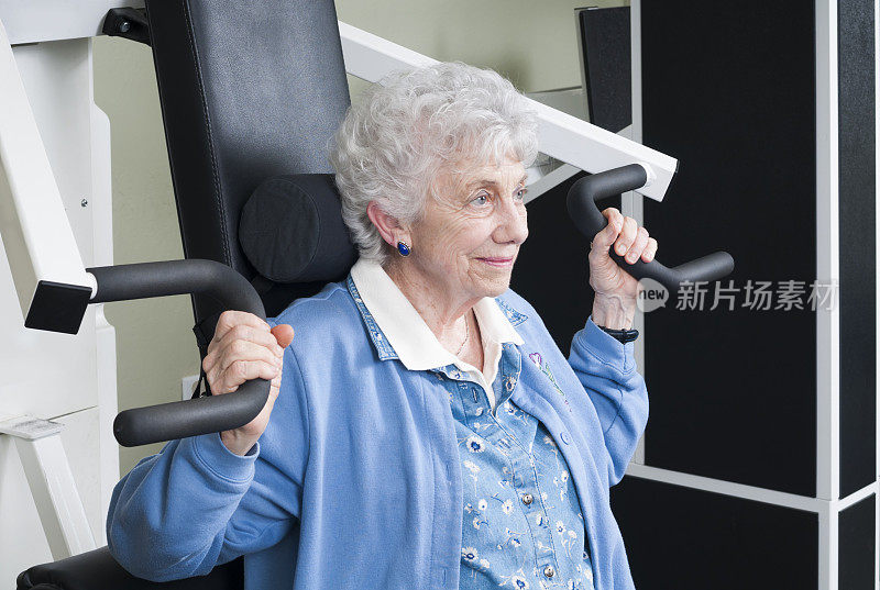 老年妇女使用手臂举重机