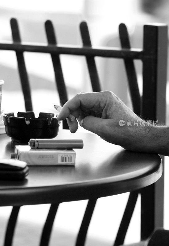 在咖啡桌上抽烟的男人