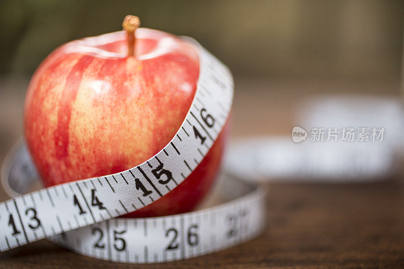 以红苹果和卷尺为主题的节食场景。