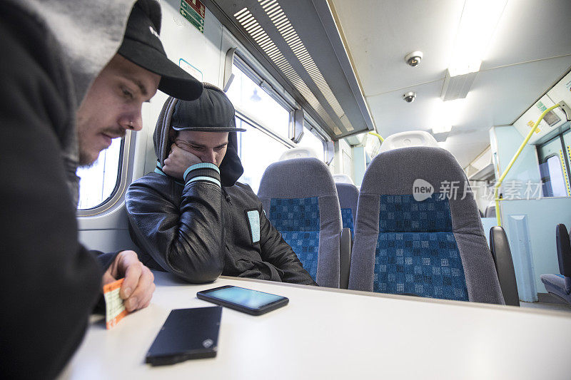 年轻的成年人在火车上使用手机