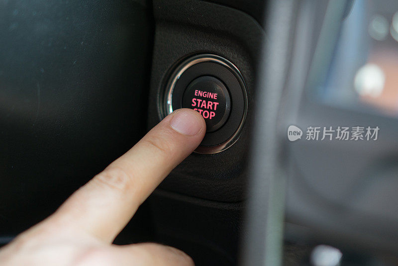 驾驶员用手按发动机启动和停止按钮。