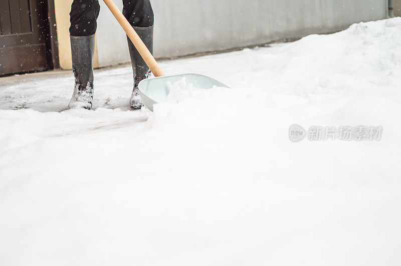 有人用雪铲清扫人行道