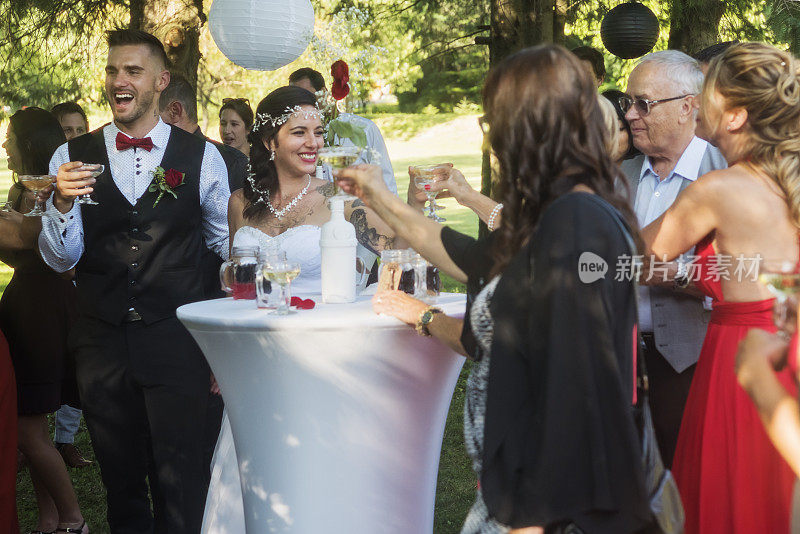 新婚夫妇在户外的婚宴上祝酒