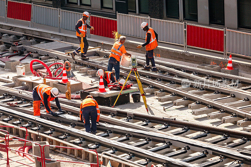 建筑工人固定和安装高速有轨电车轨道