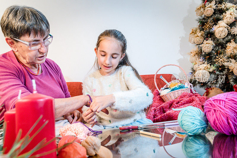 微笑的女孩编织手镯给奶奶在圣诞节时间