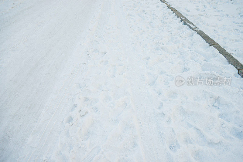 雪地上的车胎痕迹和脚印