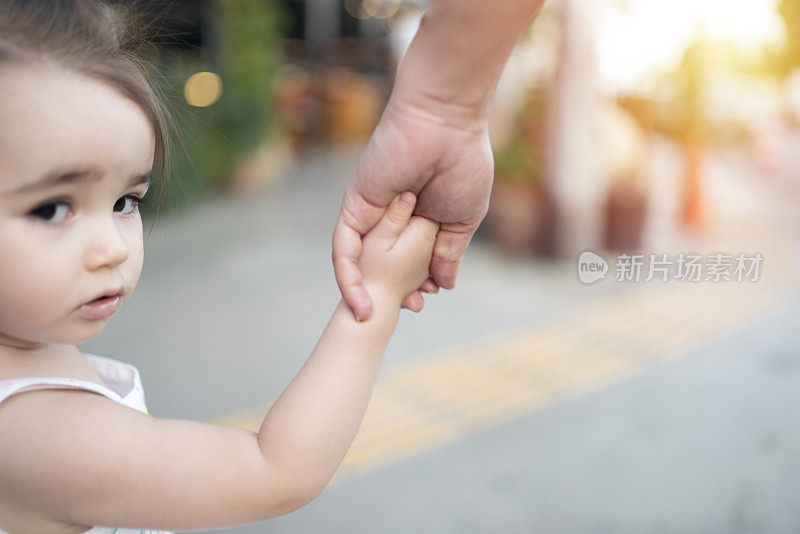 母亲和女儿手牵着手