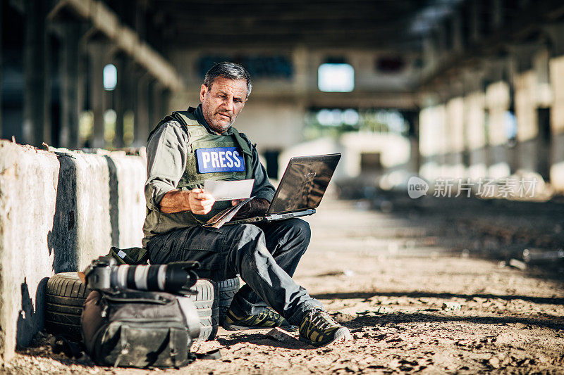 一名战地记者在战区使用笔记本电脑