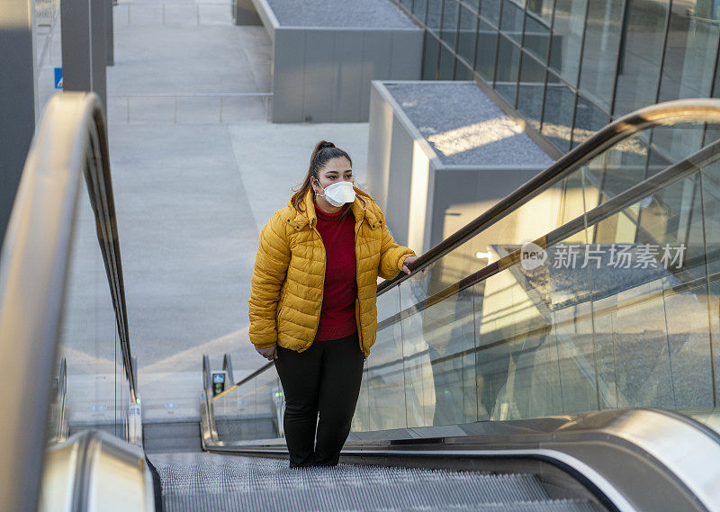 一名年轻女子在机场戴着医用口罩