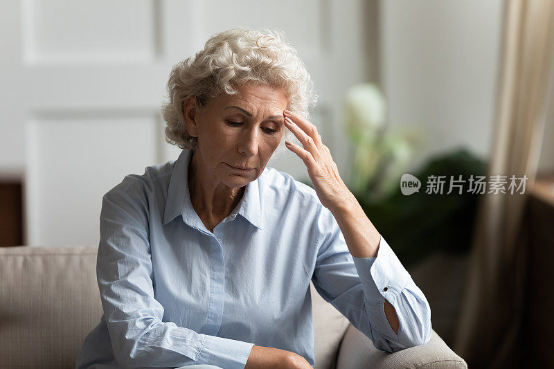 焦虑的老年妇女在家里感到孤独悲伤