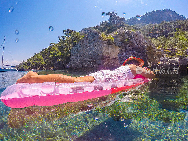 女人漂浮在干净的大海里。