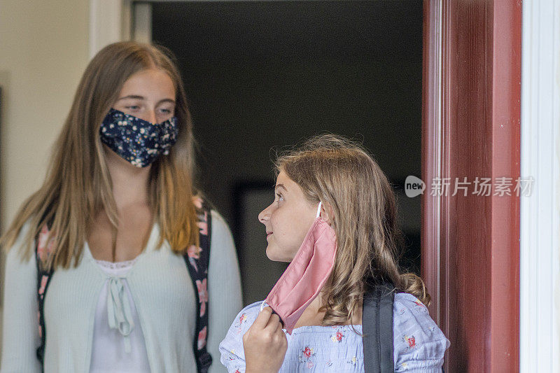 2019冠状病毒病后，姐妹们戴着口罩返回学校