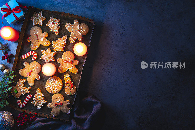 圣诞姜饼人饼干在古董烤盘雪人，星星，雪花，糖果手杖，驯鹿和冷杉