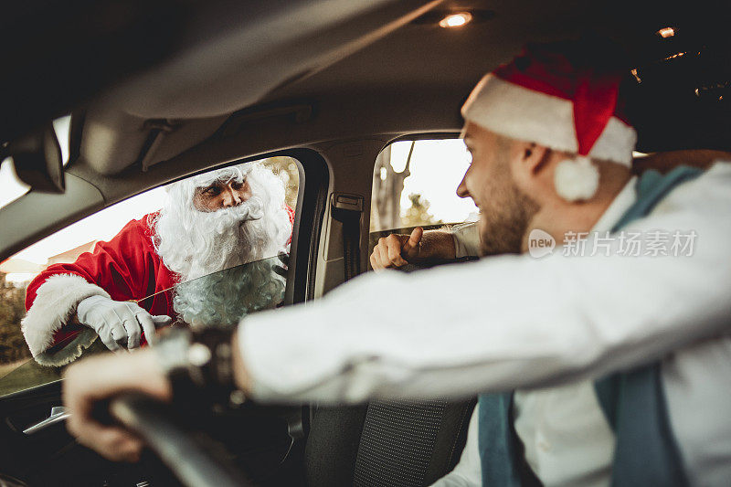 一名装扮成圣诞老人的男子停了一辆车，开始了一个疯狂的新年夜。为新年夜和最疯狂的夜晚做好准备吧。快乐的年轻人和圣诞老人在车里开了一个疯狂的派对