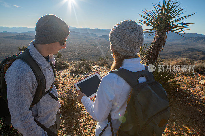 徒步旅行者使用数字平板电脑来确定路线和方向