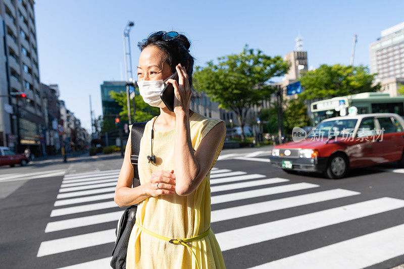 美丽的日本女人戴着面具走在城市里