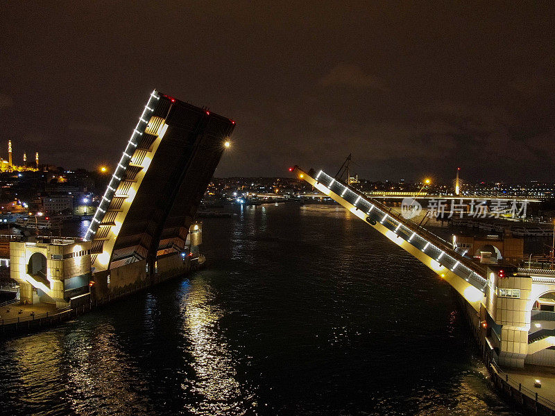 加拉塔吊桥开启。从伊斯坦布尔博斯普鲁斯海峡看加拉塔大桥的夜景。土耳其伊斯坦布尔
