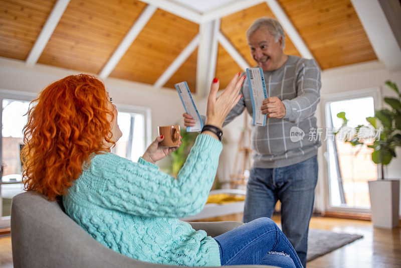 白人老男人用度假的机票给他妻子一个惊喜