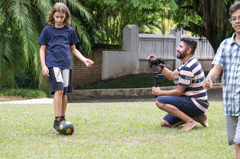 摄影师和踢足球的孩子们