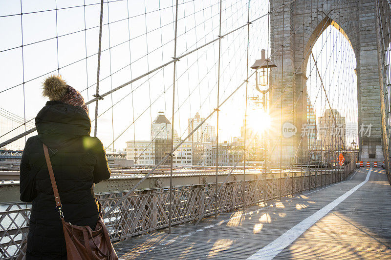 从布鲁克林大桥拍摄纽约市天际线的女人