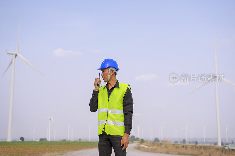 电力工地的蓝领工人。风车。