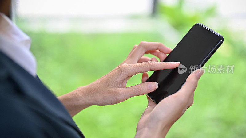 一名女性使用现代智能手机，触摸屏幕，在社交媒体上滚动。
