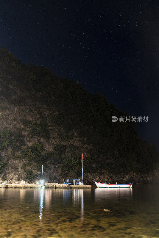 码头上的划艇和码头上的桌椅的夜景