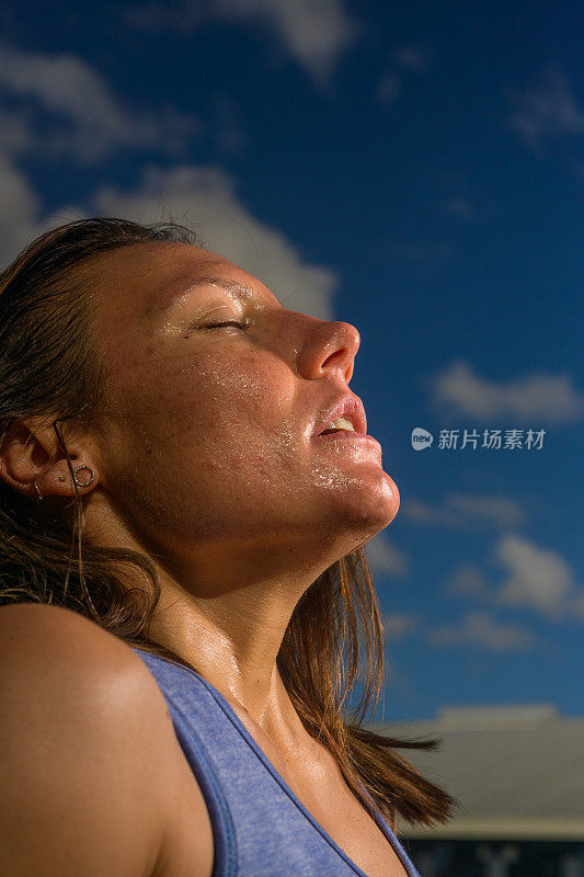 特写画像美丽的女运动员出汗，看起来疲惫的运动后