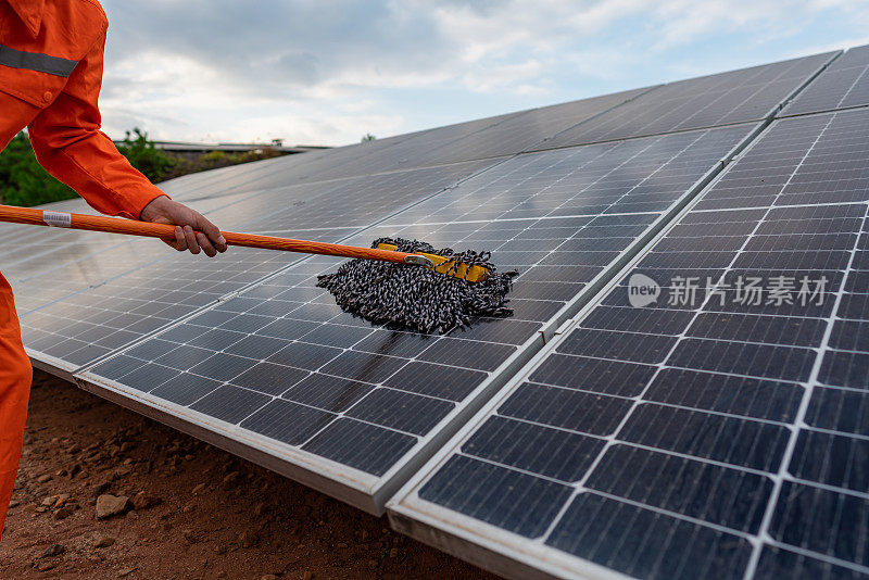 工人们用拖把清洁太阳能电池板